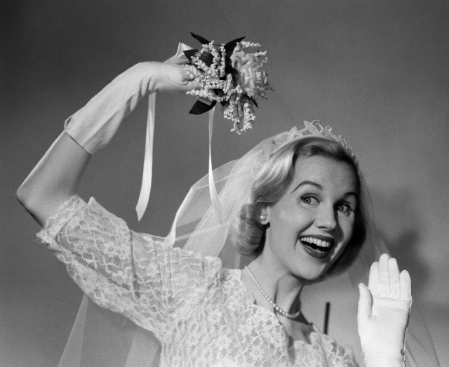 1950s bride throwing bouquet and waving goodbye smiling